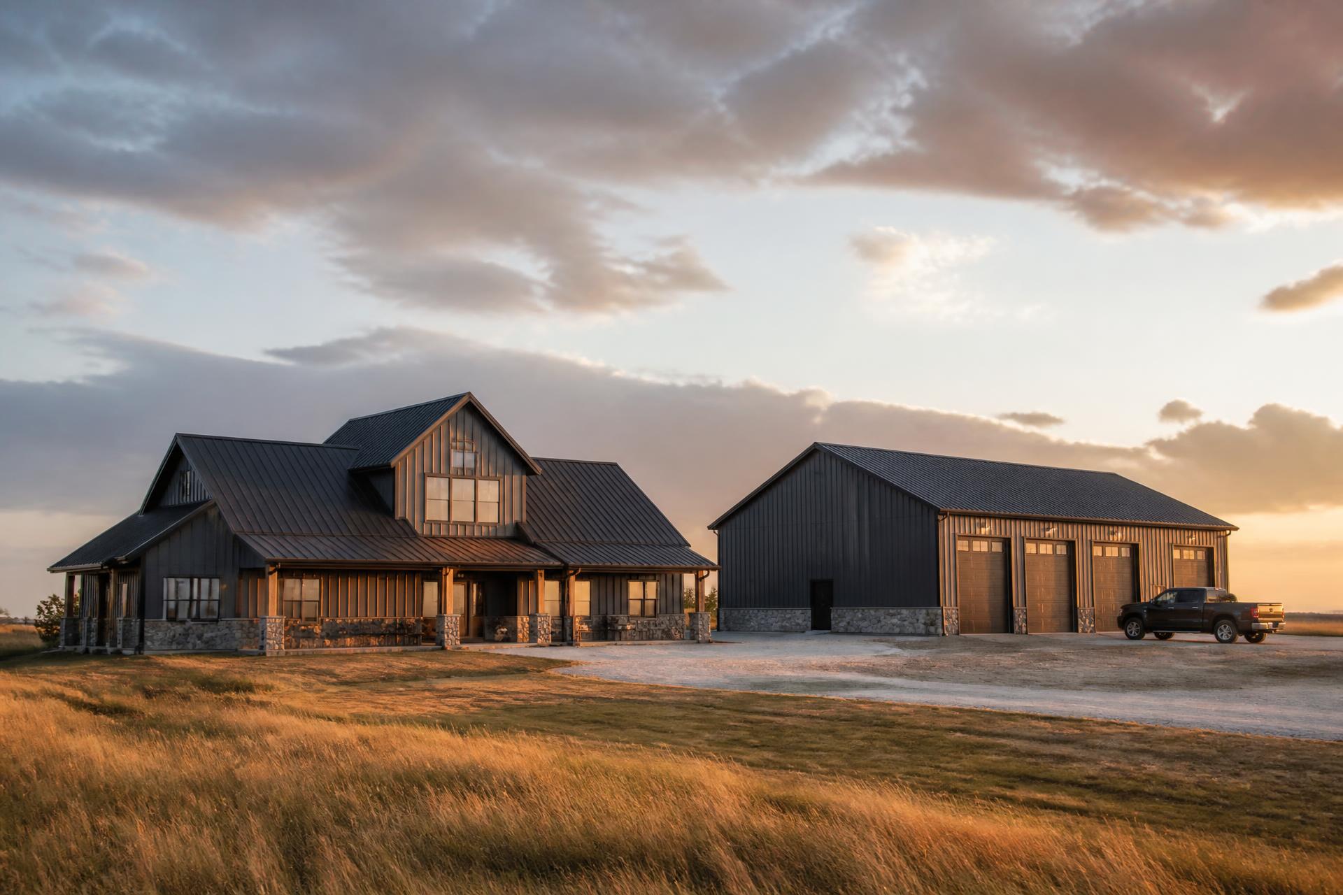 Acreage home and shop finished with dark metal roofing and siding at sunset